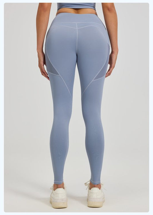 Person wearing light blue leggings on a plain background