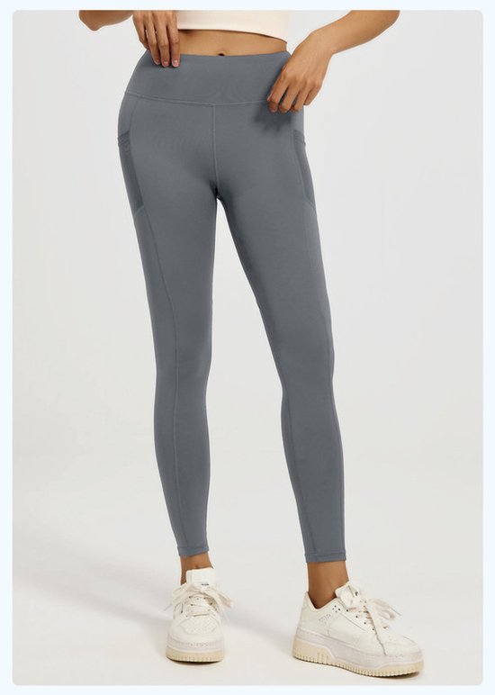 Person wearing gray leggings with white sneakers on a light background