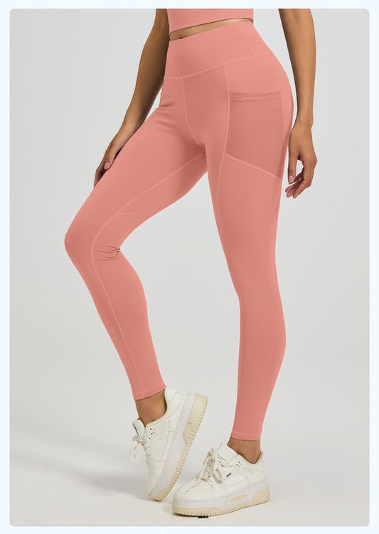 Person wearing pink leggings and white sneakers on a light gray background