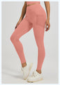 Person wearing pink leggings and white sneakers on a light gray background