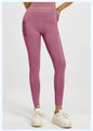 Person wearing dark pink leggings and white sneakers on a light gray background