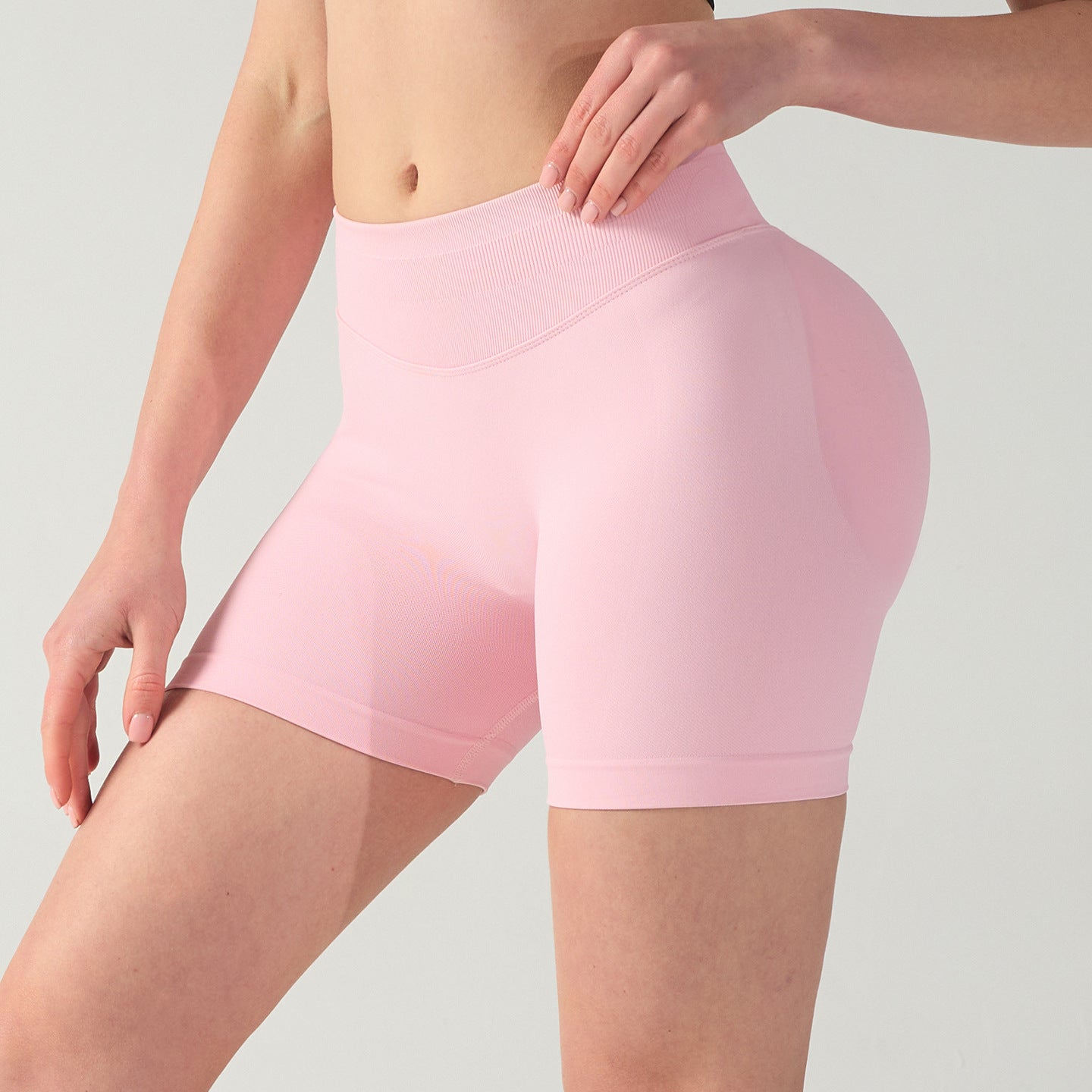 Person wearing pink athletic shorts on a light gray background