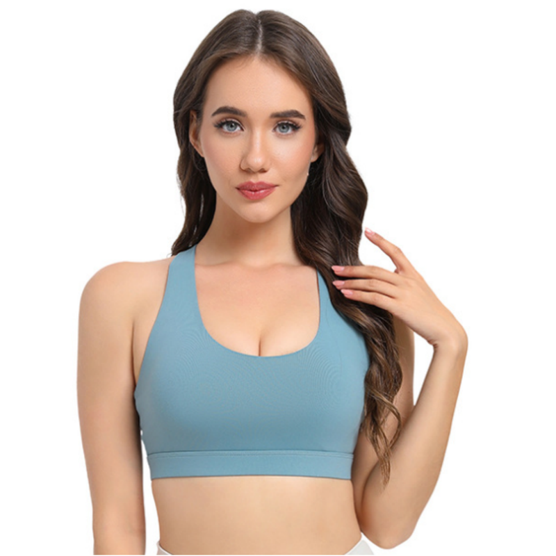 Woman wearing a blue sports bra on a light gray background
